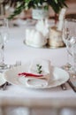 Wedding ceremony decoration in the restoraunt. The composition of green sprig eucalyptus flowers on festive table with white table