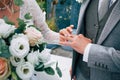 Wedding ceremony of dressing gold rings with a bouquet of white and pink flowers in the hands of the bride Royalty Free Stock Photo