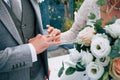 Wedding ceremony of dressing gold rings with a bouquet of white and pink flowers Royalty Free Stock Photo