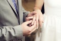 Wedding ceremony. Groom puts on golden wedding ring to bridal`s finger closeup. Bride and groom. Royalty Free Stock Photo