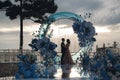 Charming couple in love in a chic banquet room in the open air against the backdrop of the sea on a gala wedding day