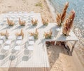 Wedding ceremony by the river. White wooden rustic style stage with chairs and flowers decorated wedding arch