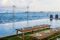 Wedding ceremony setup near the ocean at sunset - rattan benches for guests with flower petals and bamboo fans, and a wedding arch Royalty Free Stock Photo