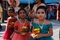 Wedding ceremony on the street. Three little Thai girls with make-up and in elegant dresses hold flowers