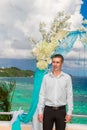 Wedding ceremony on a tropical beach in blue.The groom waits for