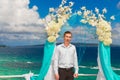 Wedding ceremony on a tropical beach in blue.The groom waits for Royalty Free Stock Photo