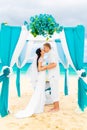 Wedding ceremony on a tropical beach in blue. Happy groom and br