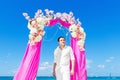 Wedding ceremony on a tropical beach in purple. The groom waits Royalty Free Stock Photo