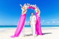 Wedding ceremony on a tropical beach in purple. The groom waits