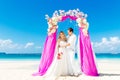 Wedding ceremony on a tropical beach in purple. Happy groom and Royalty Free Stock Photo