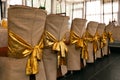 Wedding chair decoration. Beige covers and golden bowings of chair backs Royalty Free Stock Photo
