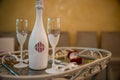 Wedding champagne bottle, two glasses and a red velvet box with the rings on a table. Royalty Free Stock Photo