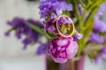 Wedding concept: bouquet of pink,purple tulips and two golden rings.Flowering branch with purple, violet flowers on Royalty Free Stock Photo