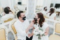 Wedding during the coronavirus period. Bride and groom in protective medical masks. Newlyweds and Covid-19 pandemic