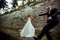 A wedding couple dance behind a stone wall Royalty Free Stock Photo