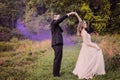 Bride and Groom dancing in forest with purple smoke Royalty Free Stock Photo