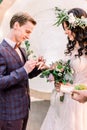 Wedding couple exchange rings on wedding ceremony outdoors. Bride with a bouquet of flowers and greenery and groom in Royalty Free Stock Photo