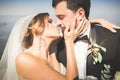 Wedding couple, groom, bride with bouquet posing near sea and blue sky Royalty Free Stock Photo