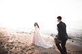 Wedding couple, groom, bride with bouquet posing near sea and blue sky Royalty Free Stock Photo