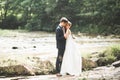 Wedding couple, groom and bride hugging, outdoor near river