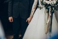 Wedding couple holding hands close up at matrimony wedding ceremony in church. stylish bride and groom hugging. emotional moment, Royalty Free Stock Photo