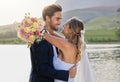 Wedding, couple hug and lake with a bride feeling love, care and support from marriage together. Nature, flower bouquet Royalty Free Stock Photo