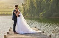 Wedding couple, hug and love by lake in nature for relax or romantic honeymoon getaway. Calm woman hugging man in happy Royalty Free Stock Photo