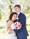 Wedding couple hugging, the bride holding a bouquet of flowers, groom embracing her Royalty Free Stock Photo