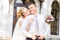 Wedding couple hugging, bride holding a bouquet of flowers, the groom embracing her Royalty Free Stock Photo