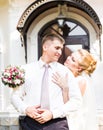 Wedding couple hugging, bride holding a bouquet of flowers, the groom embracing her Royalty Free Stock Photo