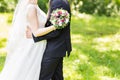 Wedding couple hugging, bride holding a bouquet of flowers, the groom embracing her Royalty Free Stock Photo