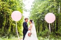 Wedding couple hugging, the bride holding a bouquet of flowers, groom embracing her outdoors Royalty Free Stock Photo