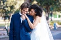 Wedding, couple and kiss while holding hands outdoor at marriage celebration event together with commitment. Interracial Royalty Free Stock Photo