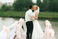 A wedding couple kisses tenderly standing on a bridge decorated Royalty Free Stock Photo