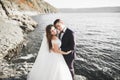 Wedding couple kissing and hugging on rocks near blue sea Royalty Free Stock Photo