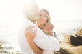 Wedding couple kissing and hugging on rocks near blue sea Royalty Free Stock Photo