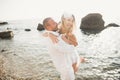 Wedding couple kissing and hugging on rocks near blue sea Royalty Free Stock Photo