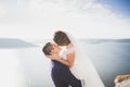 Wedding couple kissing and hugging on rocks near blue sea Royalty Free Stock Photo