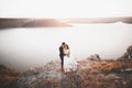 Wedding couple kissing and hugging on rocks near blue sea Royalty Free Stock Photo