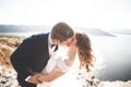 Wedding couple kissing and hugging on rocks near blue sea Royalty Free Stock Photo