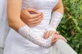Wedding couple in nature. the hands of the groom embrace the bride. the bride in white gloves Royalty Free Stock Photo