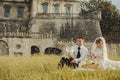 Wedding couple picnic on the grass in the front of an old castle
