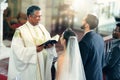 Wedding, couple and priest with a bible in church praying to God with a Christian pastor reading the holy book. Love Royalty Free Stock Photo