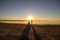 Wedding couple on the sea beach watching sunset. Sunny summer photo. Bride with hair down in off shoulder dress with train. Ocean Royalty Free Stock Photo