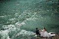 Wedding couple sitting at the table and celebrating their marriage on the river, general up view