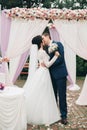 Wedding couple standing under an arch of fresh flowers Royalty Free Stock Photo