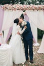 Wedding couple standing under an arch of fresh flowers Royalty Free Stock Photo