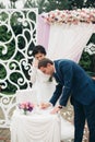 Wedding couple standing under an arch of fresh flowers Royalty Free Stock Photo