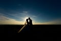 wedding couple with the sunset. Silhouette of Bride and Groom kissing on the romantic wedding