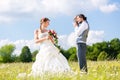 Wedding couple taking pictures on meadow